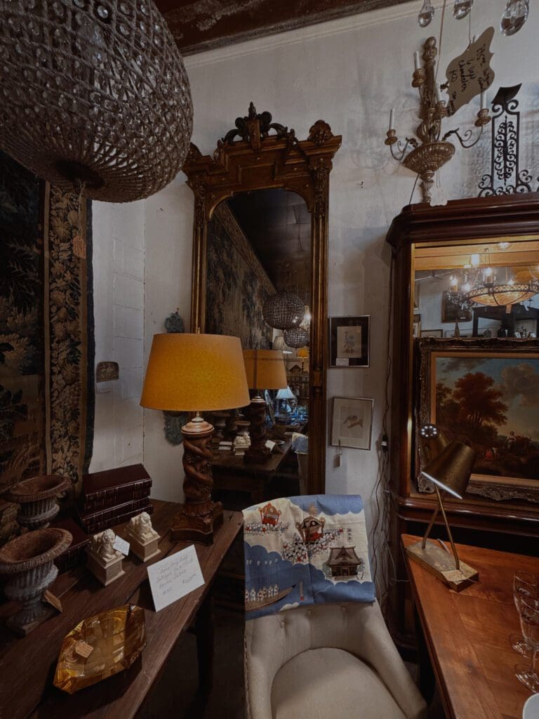 Moody maximalist corner with layered vintage mirrors and warm earth tones 2026 interior design