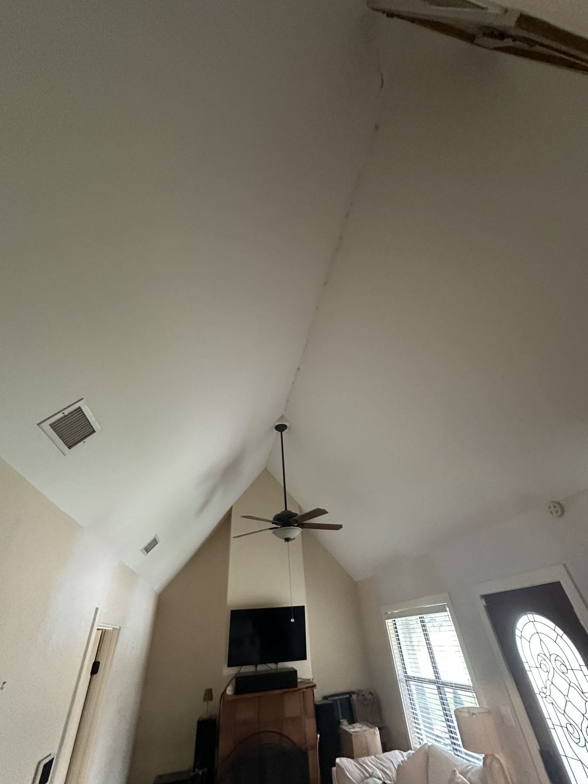 Vaulted ceiling after the cedar beam was removed, showing bare white drywall.