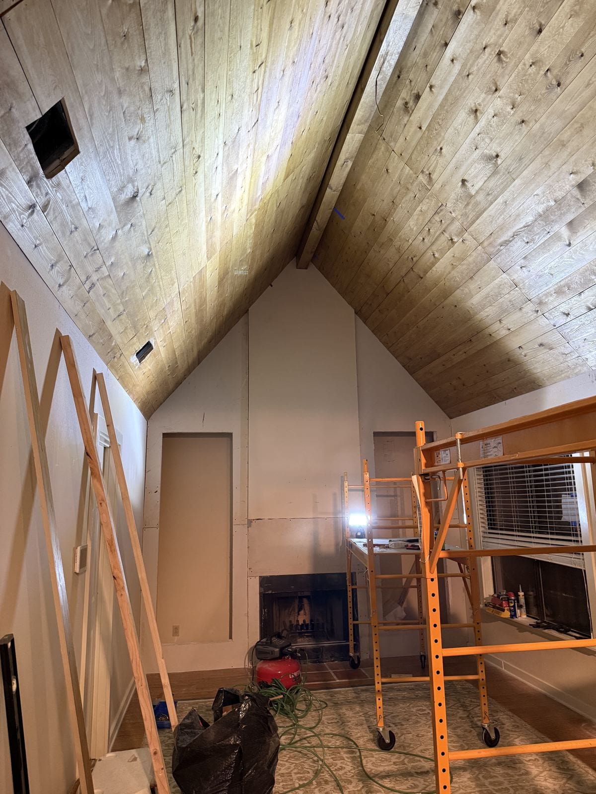 Pine plank vaulted ceiling with built-in cabinet bases framed around the fireplace during construction.