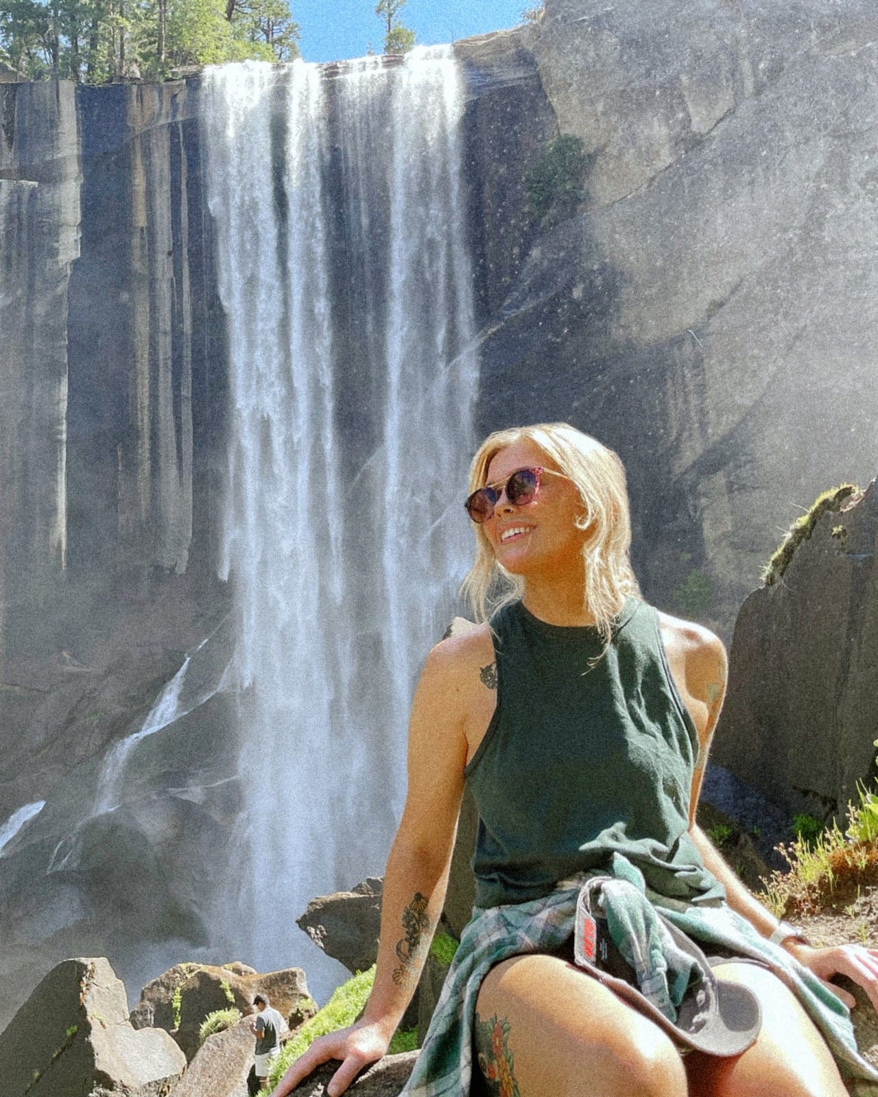 Taylor smiling in the summer sun at a waterfall