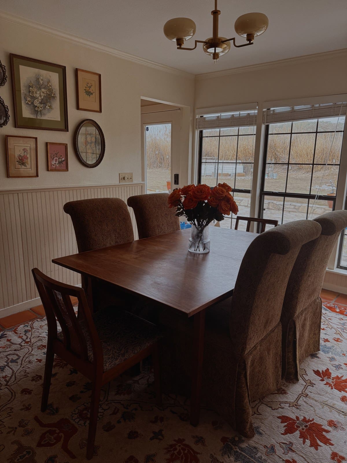 A thrifted grandmillennial dining room with a gallery wall