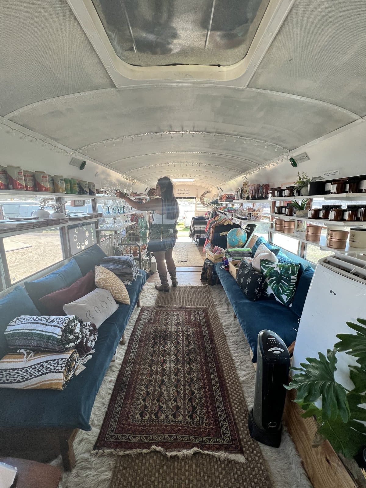The interior of a vintage bus turned shop at Round Top, lined with rugs and antiques